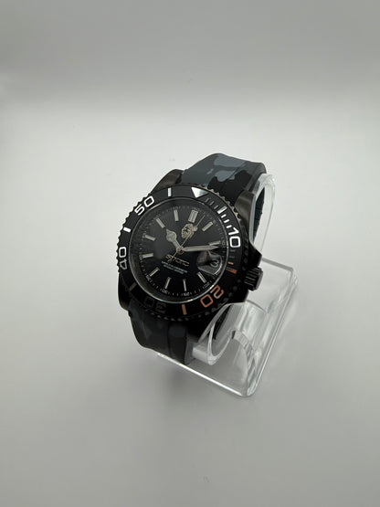 Blackout Diver at an angle, with a black dial, black numbered bezel and gray camouflage strap.