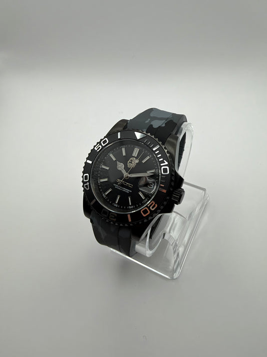 Blackout Diver at an angle, with a black dial, black numbered bezel and gray camouflage strap.
