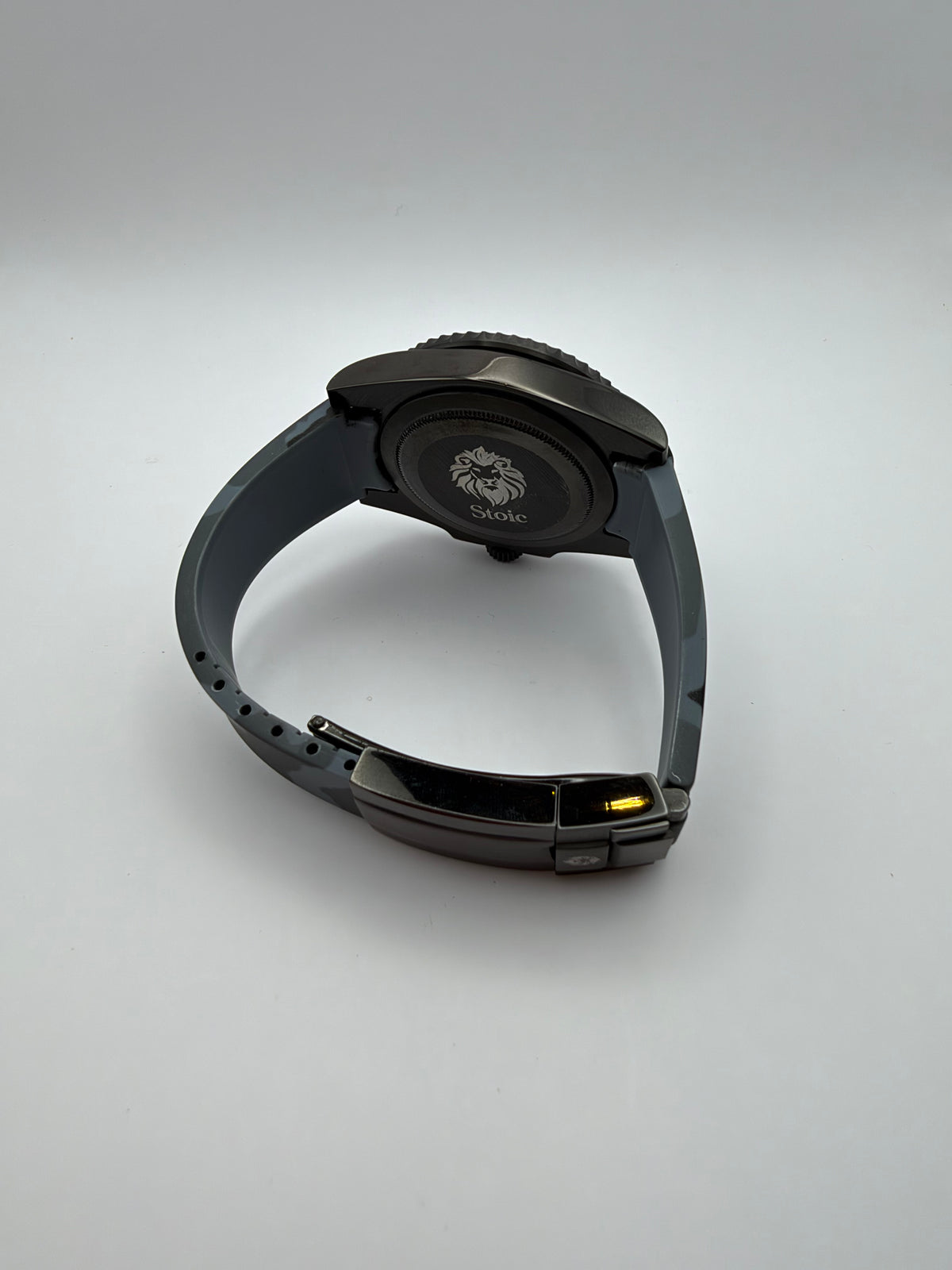 Blackout Diver rear view with a lion-engraved caseback and black clasp on its camouflage strap.
