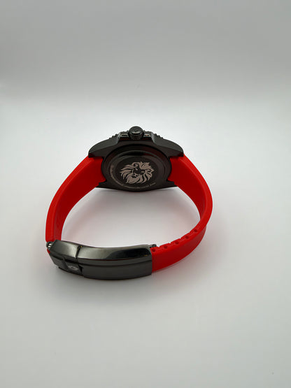 Pyra rear view with a lion-engraved black caseback, red strap and black folding clasp.
