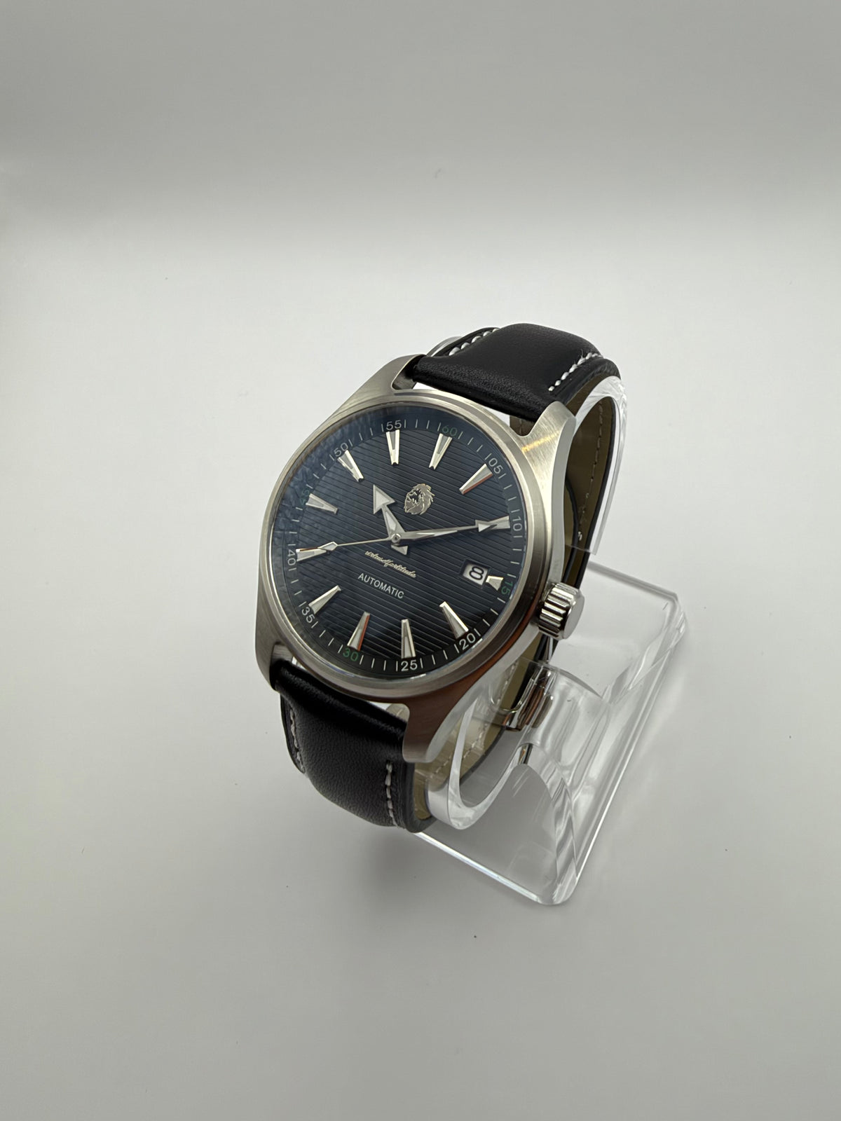 Resolute at an angle, with a dark striped dial, silver-tone case and black strap with white stitching.