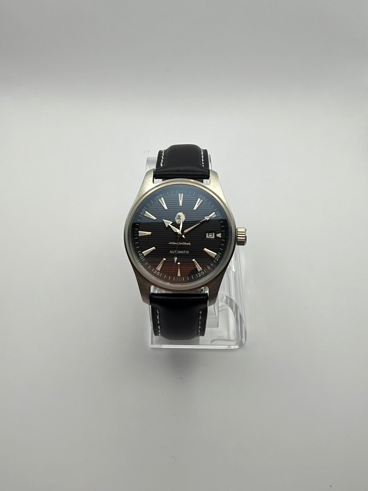 Resolute front view showing its dark striped dial, pointed hour markers and date window.