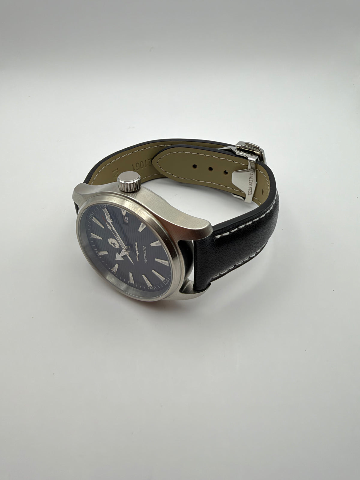 Resolute resting at an angle, showing the black stitched strap and silver-tone case profile.