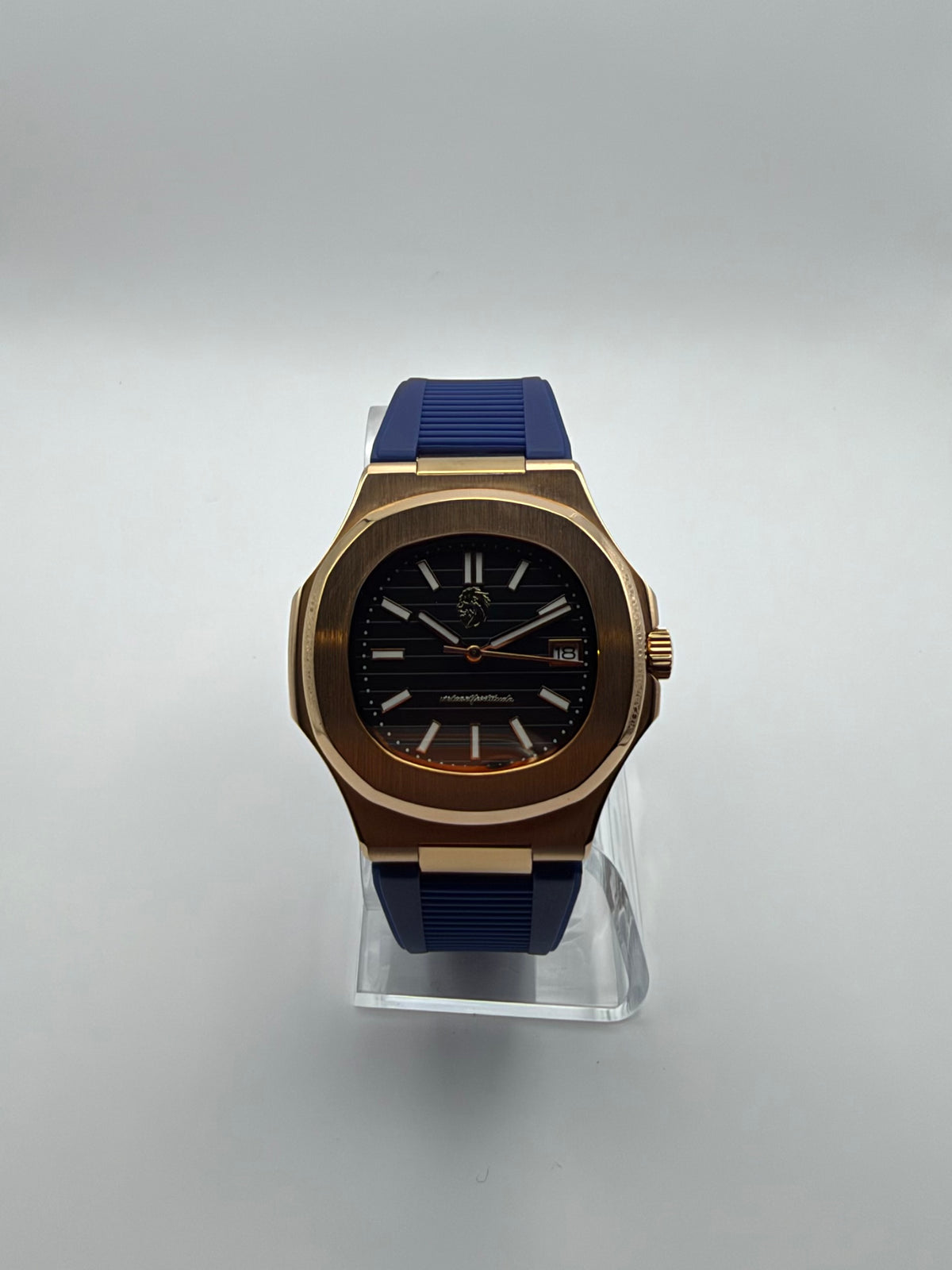 Nocturne front view, with a black striped dial, gold-tone cushion case and blue strap.