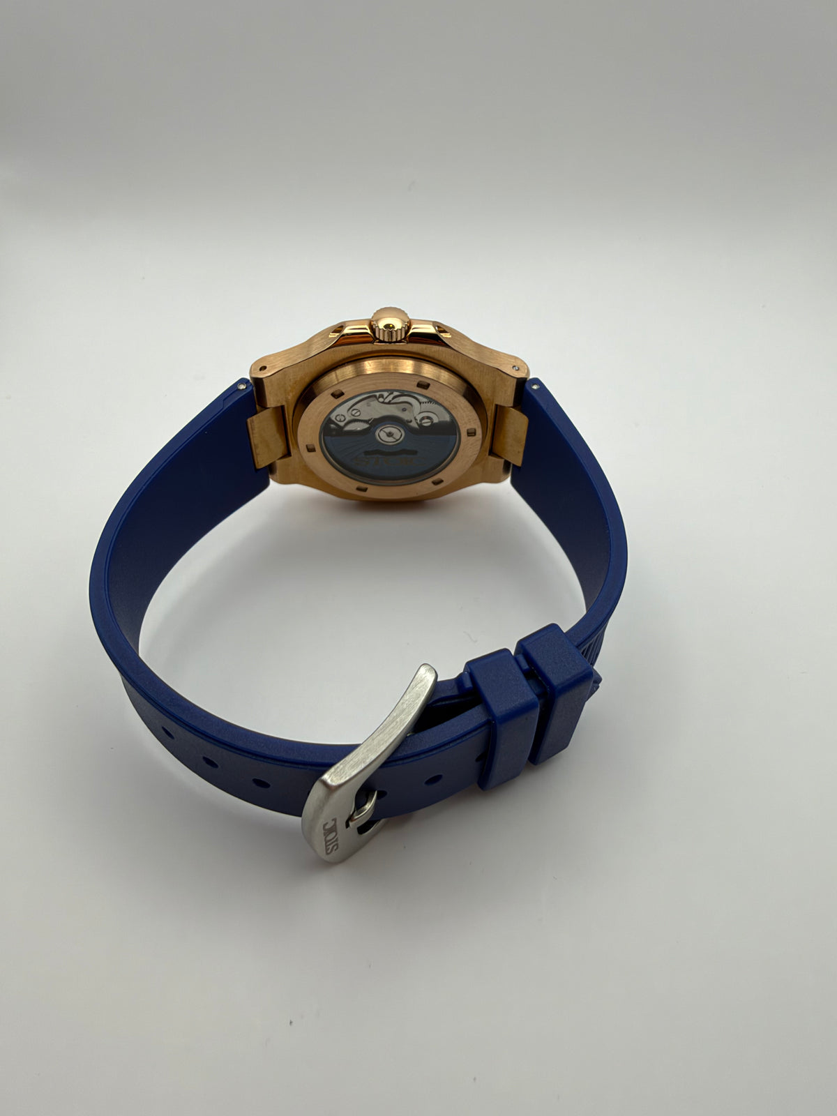 Nocturne rear view showing a display caseback, blue strap and silver-tone pin buckle.