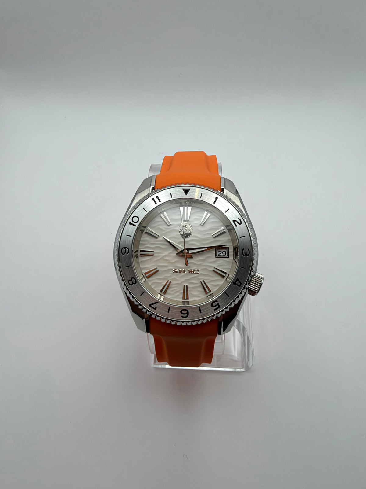 Equinox front view, with a white textured dial, silver-tone numbered bezel and orange strap.