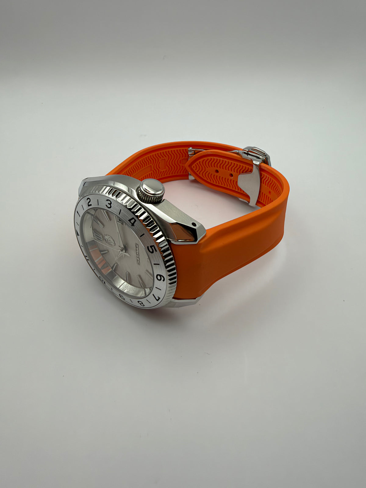 Equinox resting at an angle, showing the orange strap and silver-tone case profile.