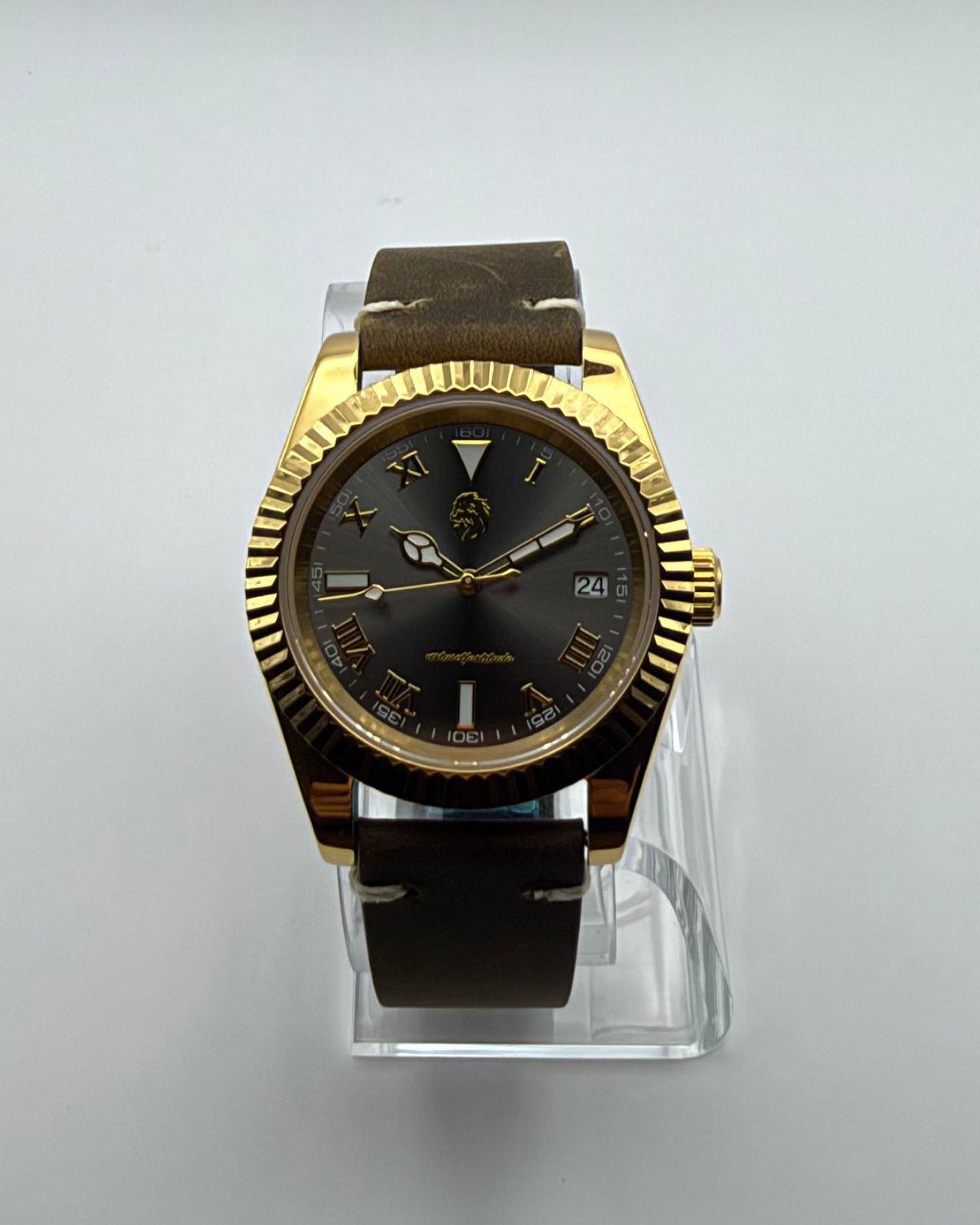 STOIC The Auctor: Front view of the dark dial, gold-tone case and brown strap.