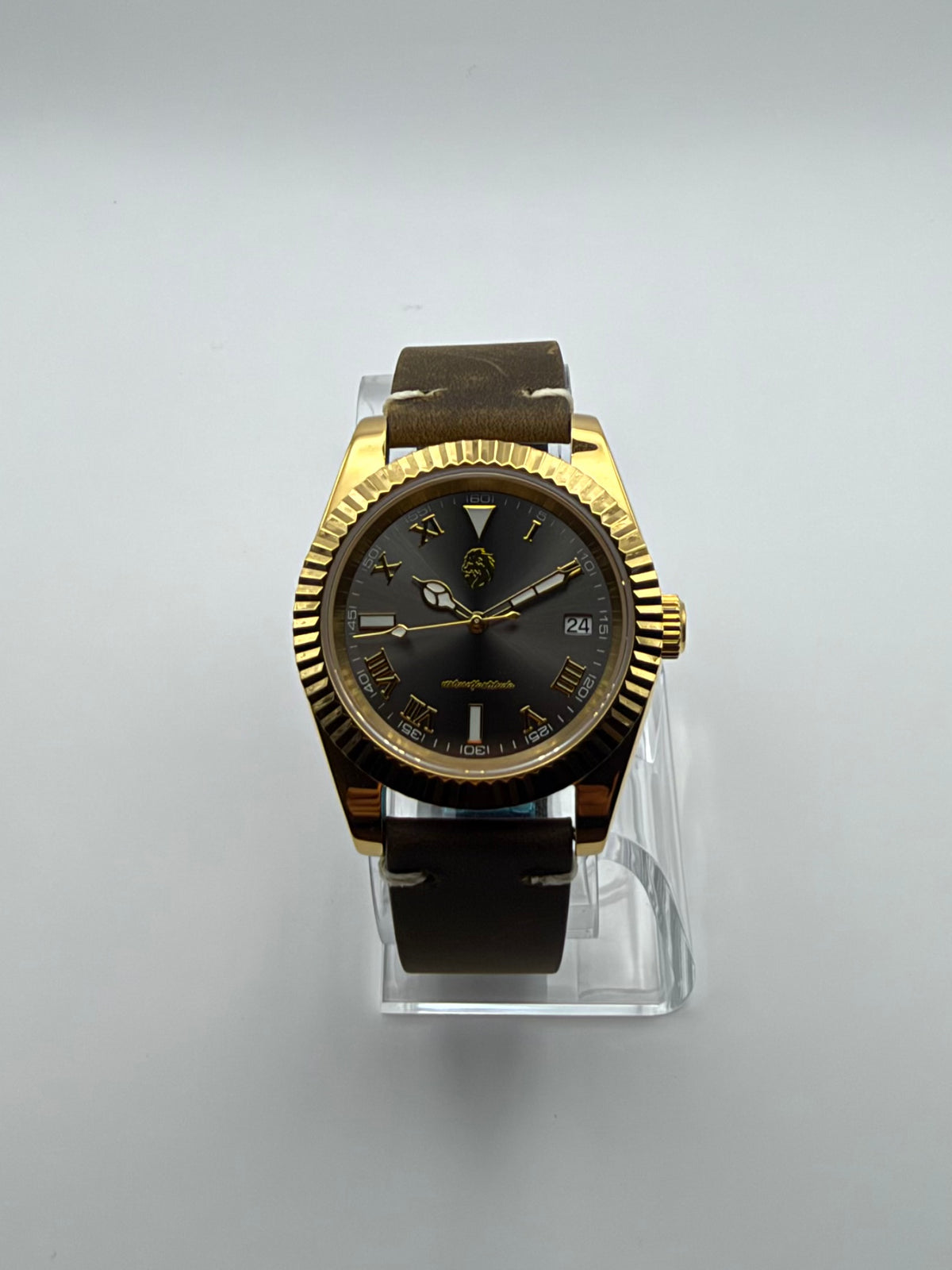 Auctor front view showing the dark dial, Roman numerals, date window and gold-tone case.