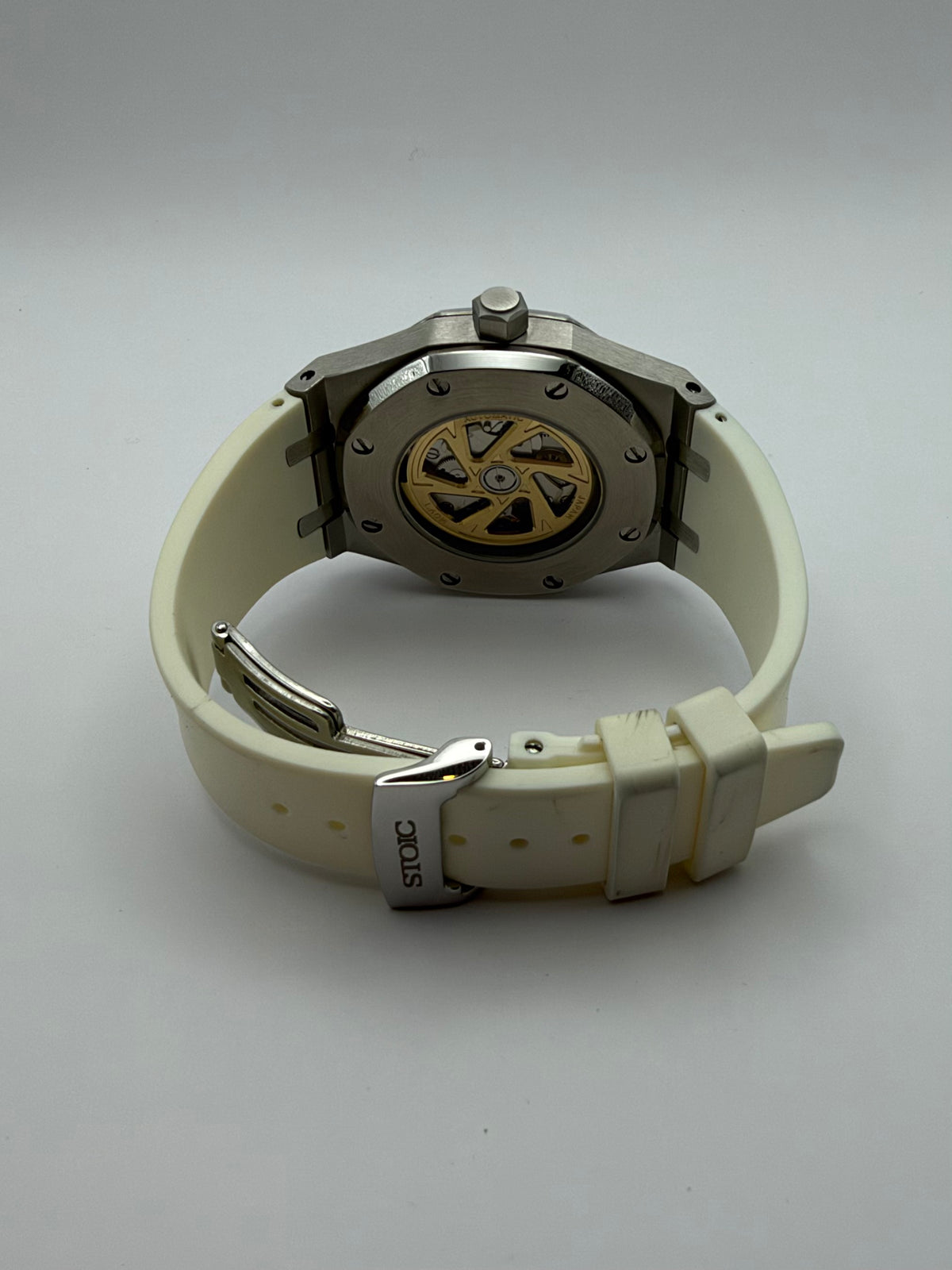 Thalassa Gold rear view with a display caseback and cream-white strap with a STOIC-marked clasp.