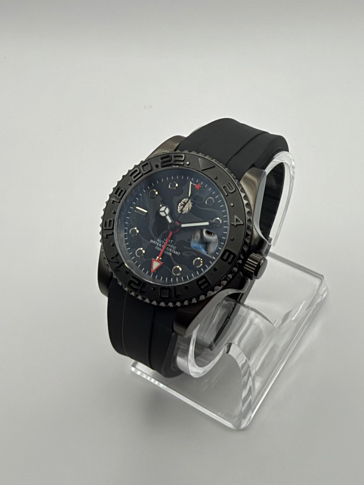 Revenant at an angle, with a dark skull-pattern dial, red arrow hand and black strap.