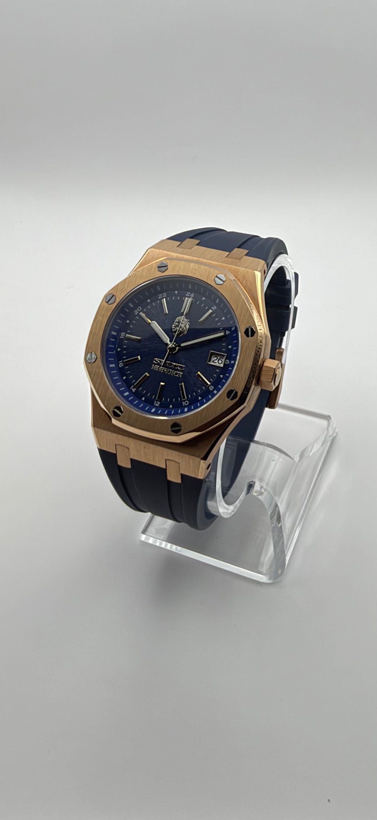 Meridian at an angle, showing its blue dial, gold-tone case and dark blue strap.