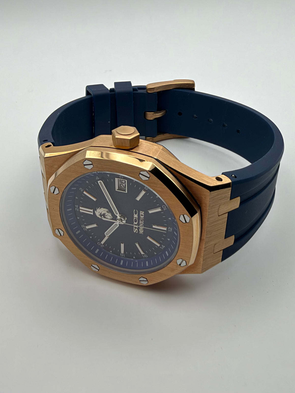 Meridian resting at an angle, showing the gold-tone case and dark blue strap.