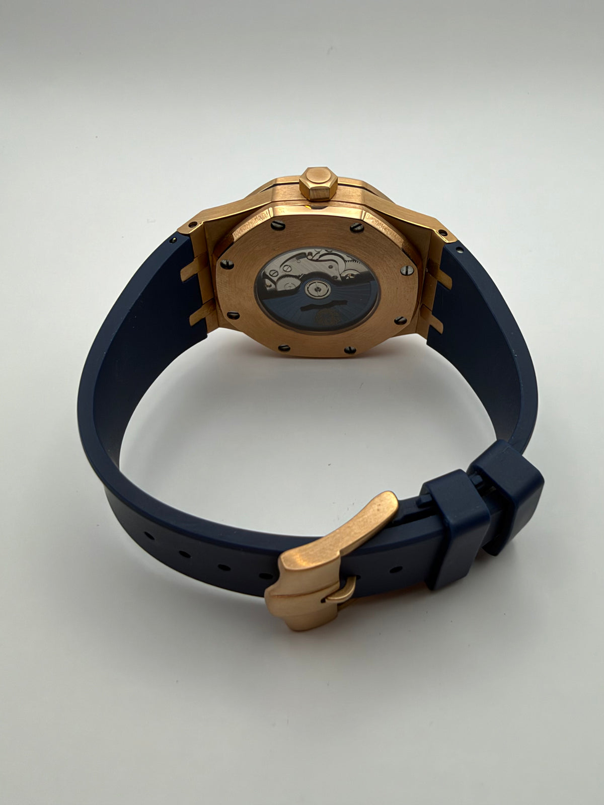 Meridian rear view showing a display caseback, dark blue strap and gold-tone buckle.