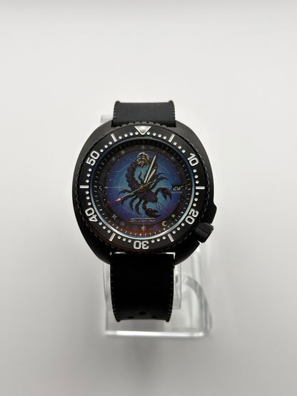 Scorpius front view showing the blue scorpion dial, date window and black bezel.