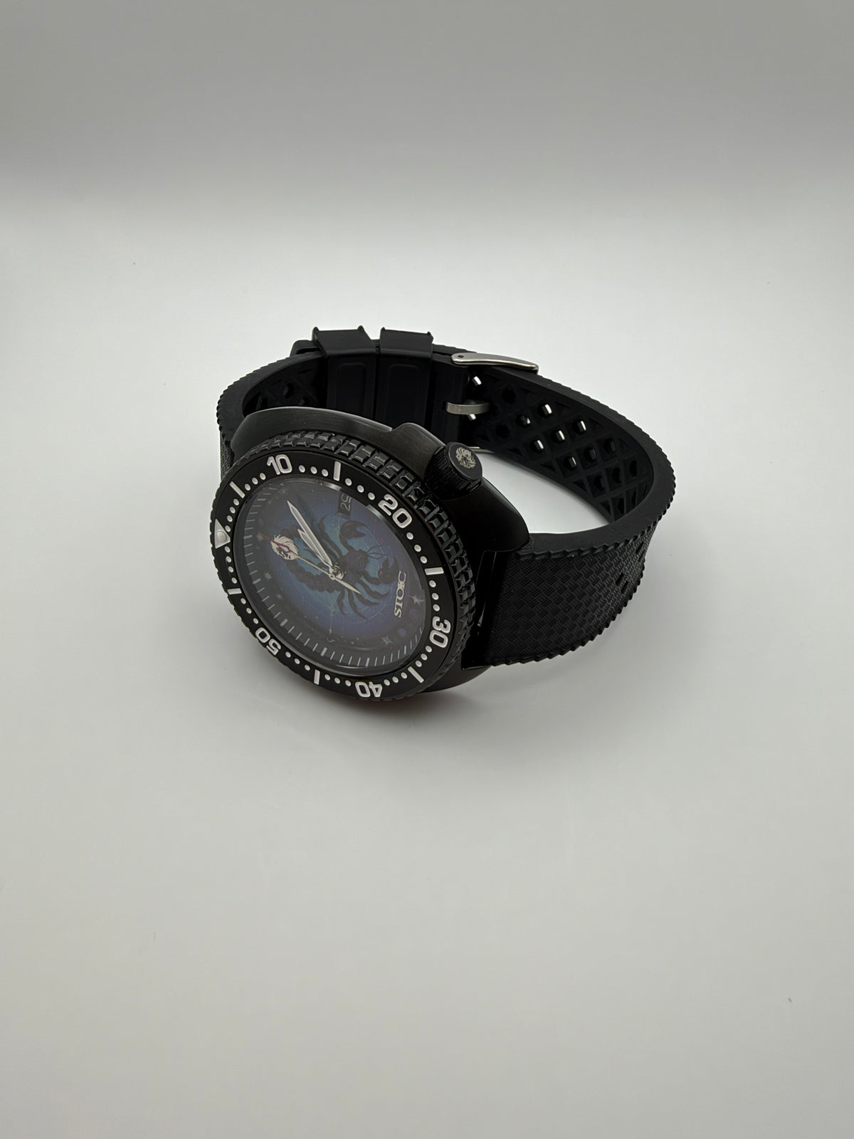 Scorpius resting on its side, showing the black case, textured strap and crown.
