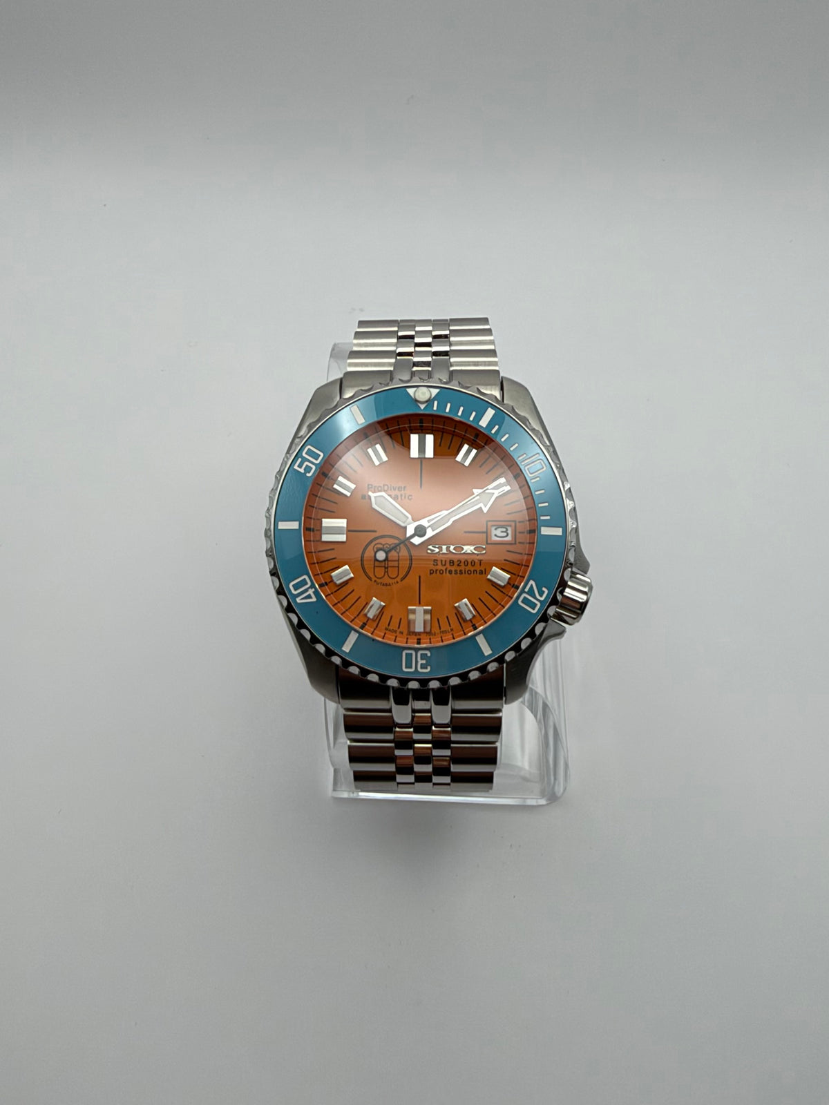 Thalassa Orange front view, with an orange dial, turquoise bezel and silver-tone link bracelet.