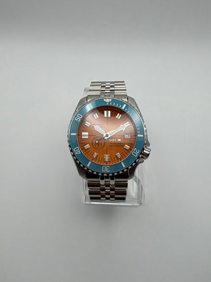 Thalassa Orange front view, with an orange dial, turquoise bezel and silver-tone link bracelet.