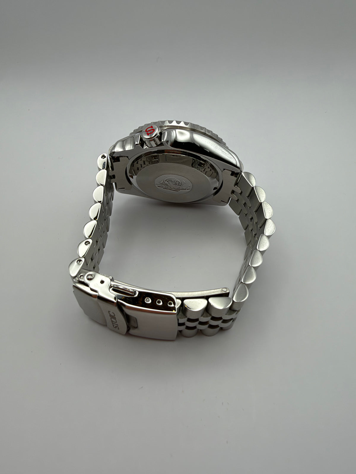 Thalassa Orange rear view showing the solid caseback, silver-tone bracelet and STOIC-marked clasp.