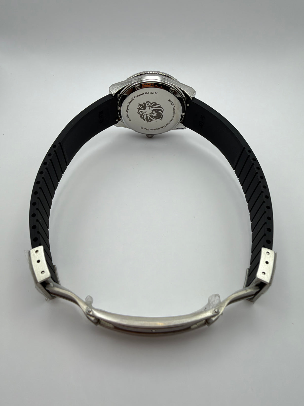 Voyager rear view with a lion-engraved caseback, black strap and open folding clasp.