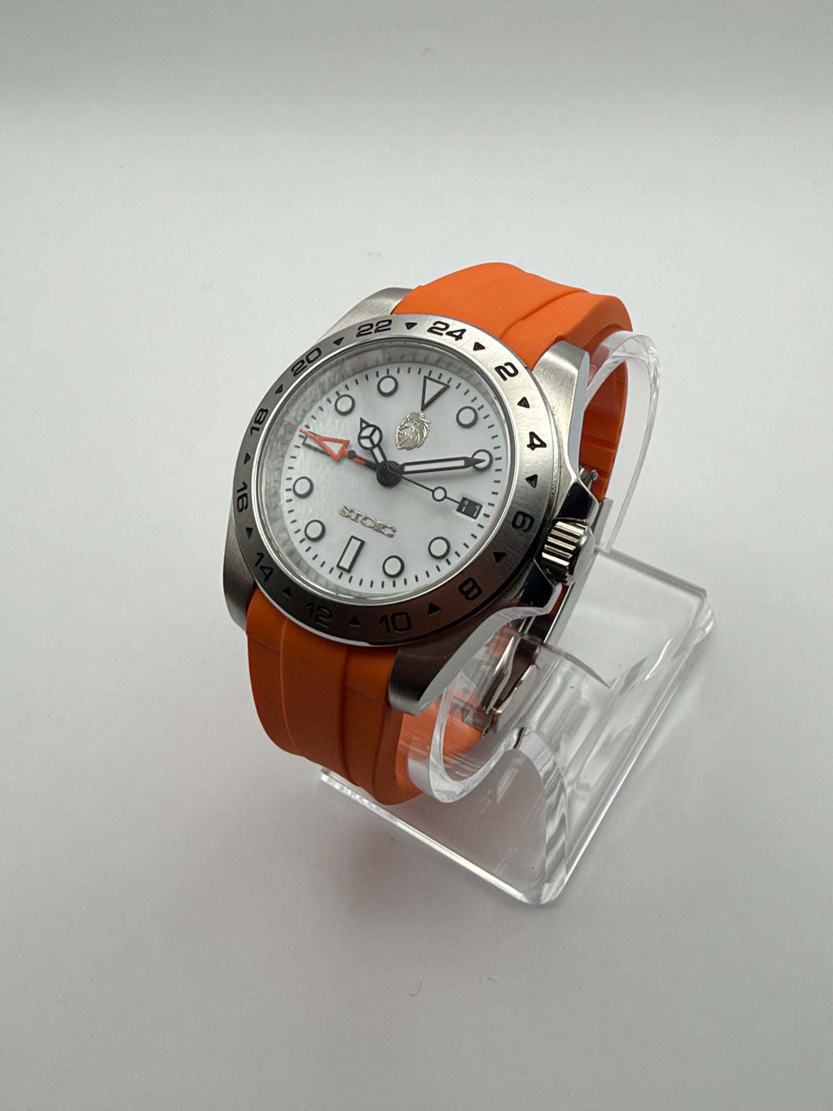 Navigator at an angle, with a white dial, silver-tone numbered bezel and orange strap.