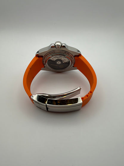 Navigator rear view showing a display caseback and orange strap with a folding clasp.