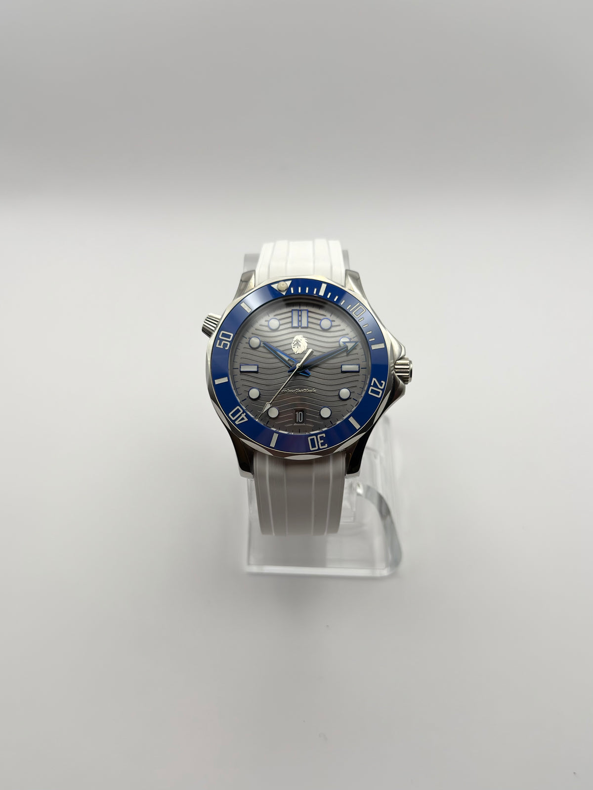 Thalassa Blue front view showing its wave-pattern dial, blue bezel and white strap.