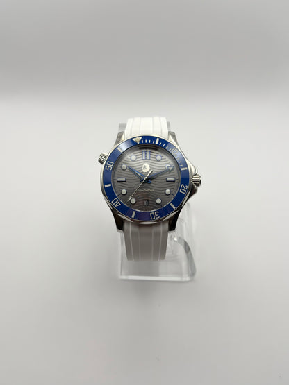 Thalassa Blue front view showing its wave-pattern dial, blue bezel and white strap.