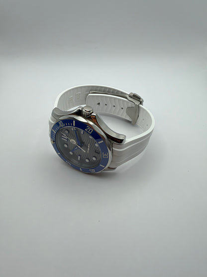 Thalassa Blue resting at an angle, showing the case profile and ridged white strap.