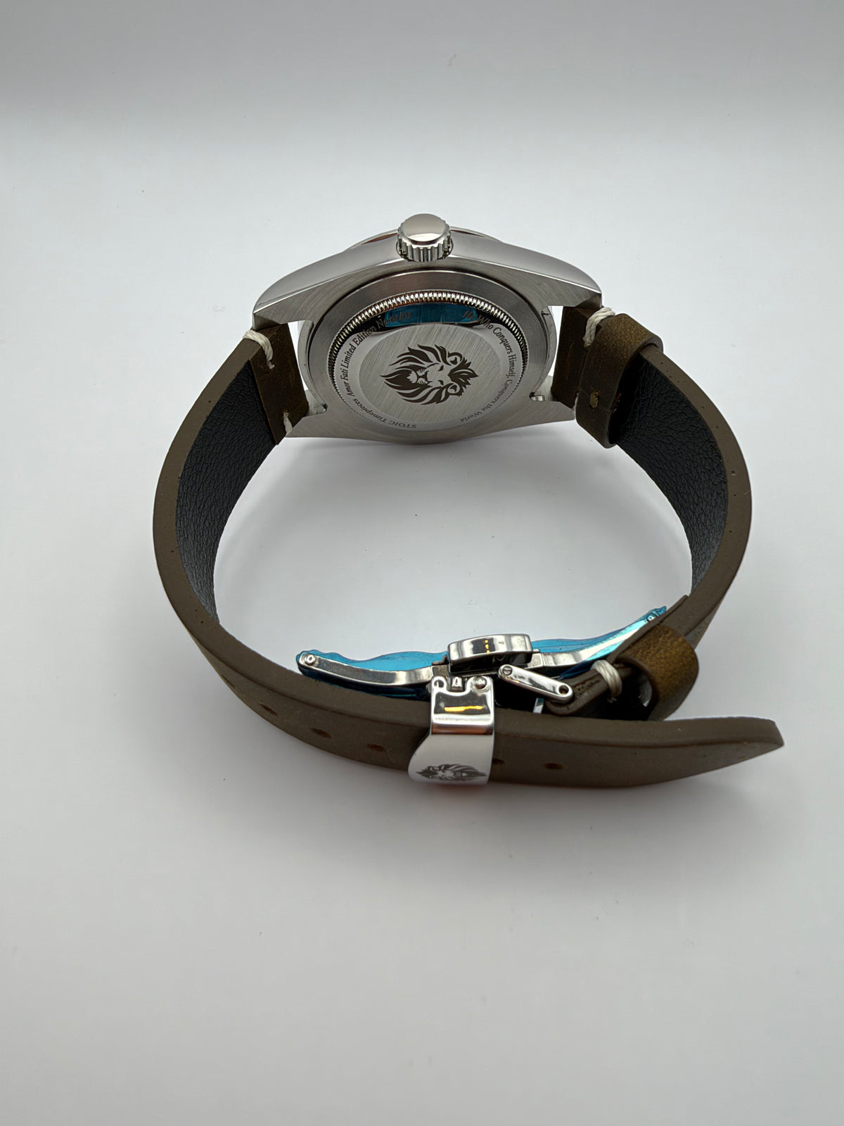 Verdant rear view with a lion-engraved caseback and brown strap with a folding clasp.