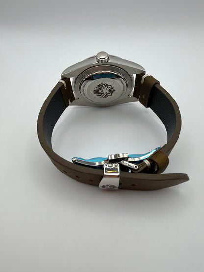 Verdant rear view with a lion-engraved caseback and brown strap with a folding clasp.